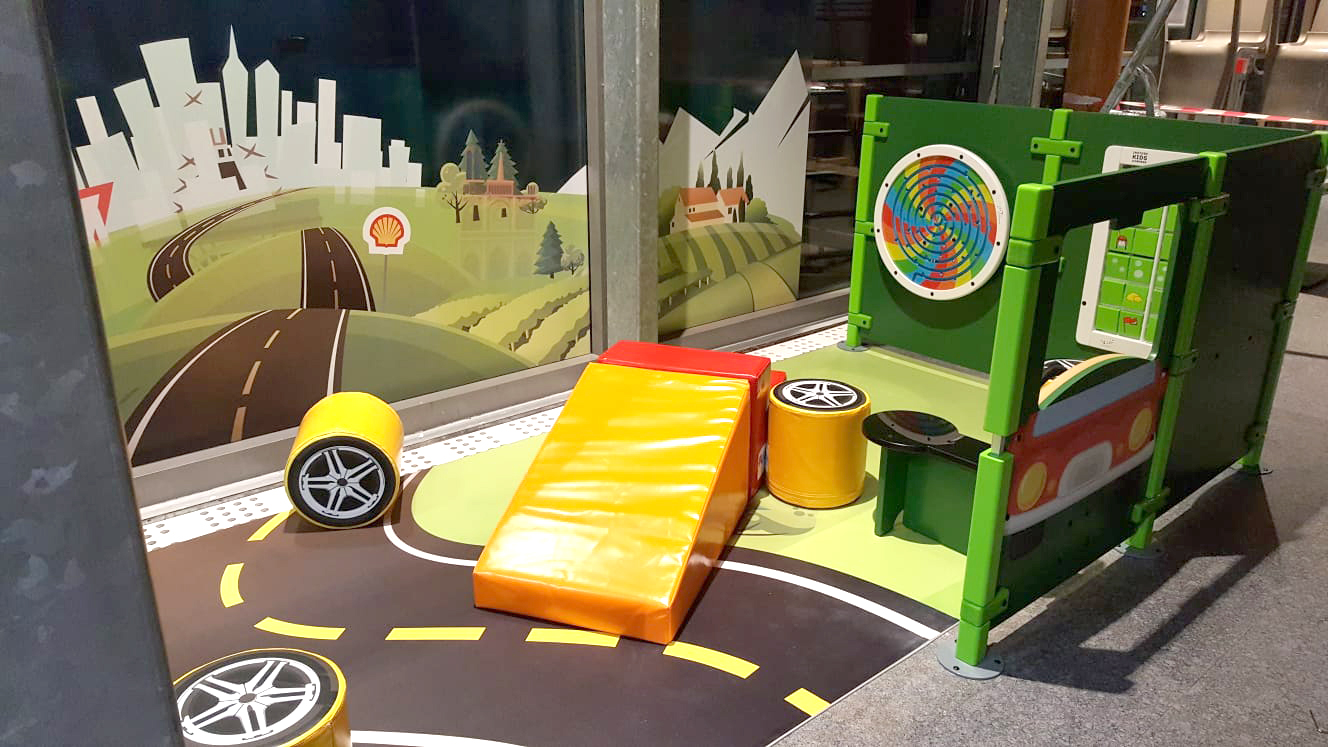 Kinderspeelhoek bij tankstation Shell in Frankrijk met verschillende speelmodules en wandspellen